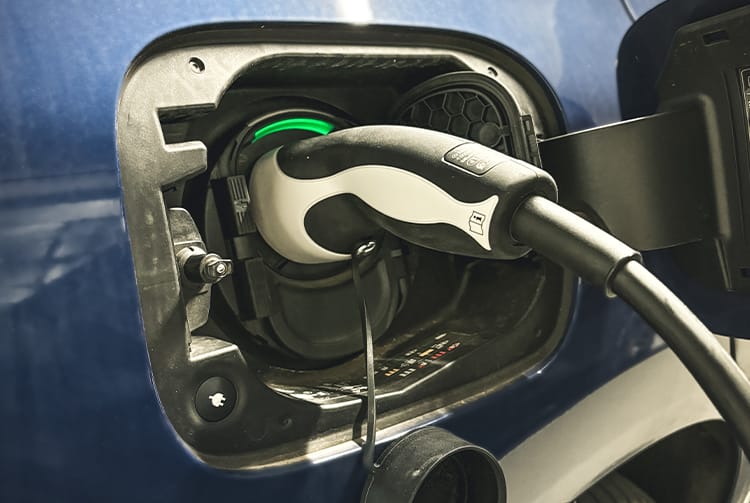 E-Ladekabel in der Ladebuchse eines blauen Autos
